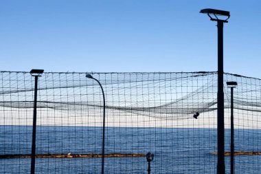 İtalya 'nın güneyindeki Bari şehrinde deniz manzaralı, lambalı bir spor ağı.