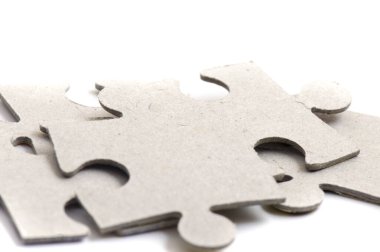 Yapboz parçalarına yakın çekim, boş beyaz yapboz parçaları birbirine bağlanmış ve ayrılmış..