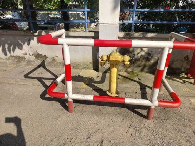 Sarı yangın musluğu, çelik bir çitle korunuyor..