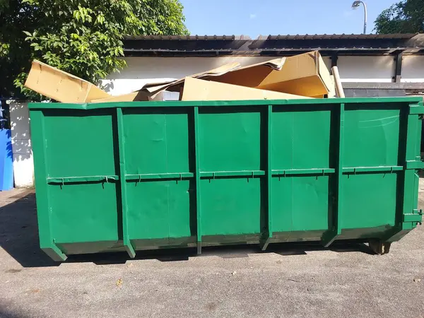 stock image Large green steel bin was filled with waste boxes