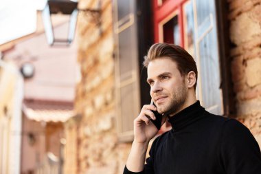 Tarz sahibi bir adam, tuhaf bir kaldırım taşı caddesinde yürürken animasyon bir telefon görüşmesi yapar..