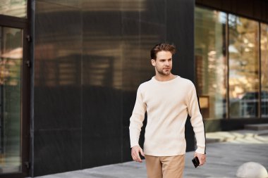 Şık bir adam modern bir şehir geçidinde güvenli adımlar atar..