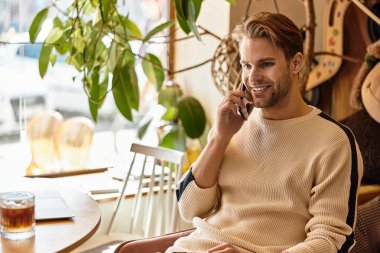 Neşeli adam canlı sokaklarda yürüyor, telefonuyla konuşuyor ve günü kucaklıyor..