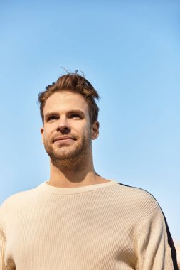 Şık bir adam kendine güvenerek yürüyor, huzurlu bir öğleden sonra boyunca açık mavi gökyüzünün tadını çıkarıyor..