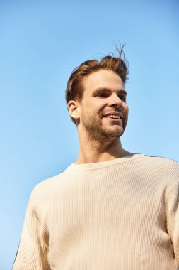 Neşeli bir adam güneşli bir günde yürür, güneşlerin altında güneşlenirken neşe saçar..