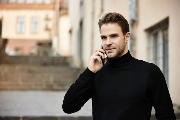 A well dressed man strolls a historic street, chatting on his phone and enjoying the day. — Stock Photo