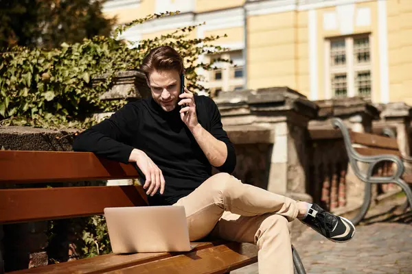 A handsome man casually walks while speaking on his phone, enjoying the fresh air and sunshine. — Stock Photo