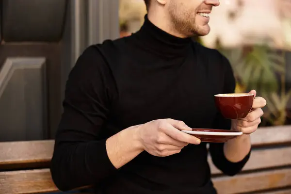 A dapper gentleman walks leisurely, savoring a steaming cup of coffee in a cozy cafe setting. — Stock Photo