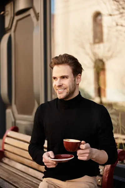 A handsome man enjoys his drink while strolling on the sidewalk, radiating confidence and warmth. — Stock Photo