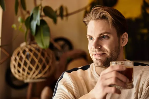 A charming man savors his beverage, radiating confidence and ease during a leisurely walk. — Stock Photo