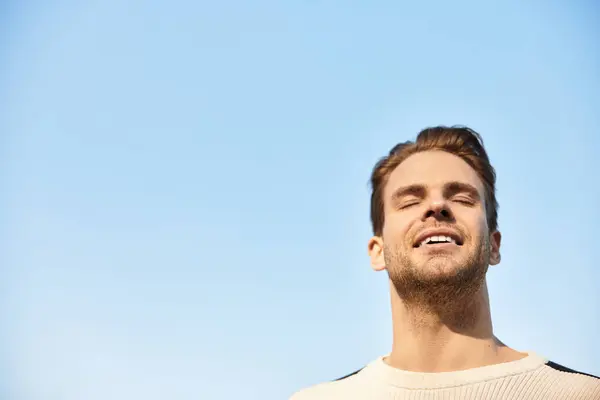 A handsome man walks with a smile, taking in the fresh air and warmth of a sunny day. — Stock Photo