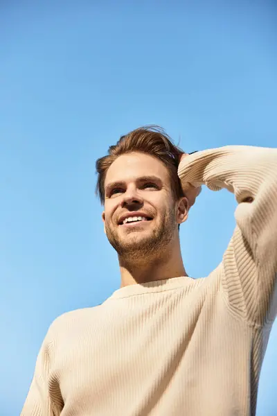 A confident man strolls happily outdoors, basking in the sunlight with a radiant grin. — Stock Photo
