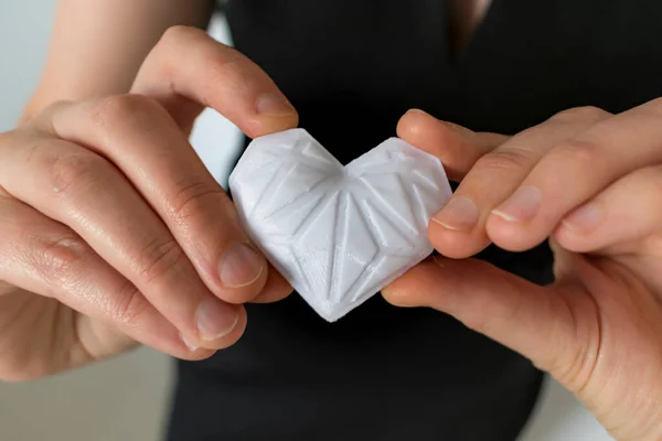 Elinde beyaz 3D baskılı kalp tutan bir kadın. Çeşitli kavramlar için ideal: aşk ve sağlık, minnettarlık ve hayırseverlik ya da teknoloji