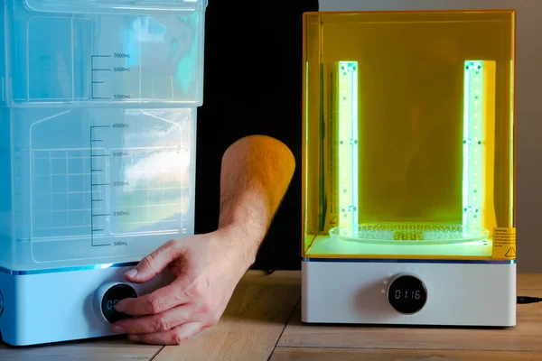 Man adjusting a wash and cure machine using UV light before use, for 3d resin printer