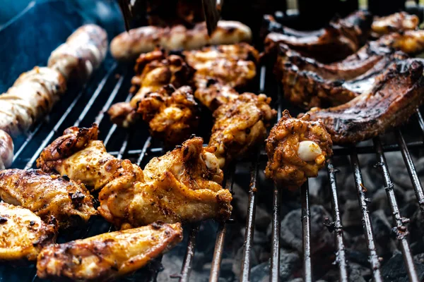 stock image Marinated meat, chicken, ribs and sausages put on the barbecue