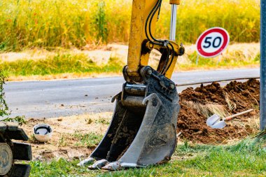 50 'de hız limiti işareti olan küçük bir kazıcı ve kova. Yol işareti.