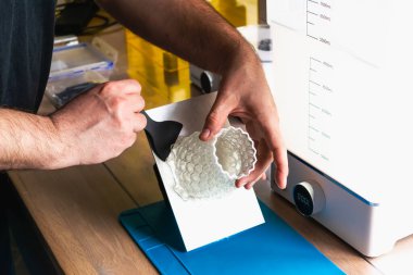 Yanında 3 boyutlu bir reçine tutan adam makineleri yıkayıp iyileştirir.