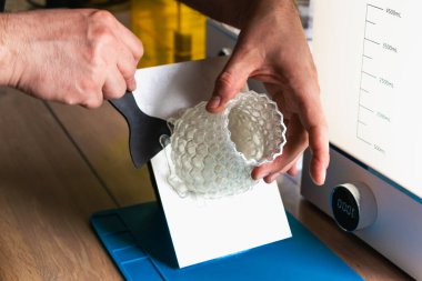 Yanında 3 boyutlu bir reçine tutan adam makineleri yıkayıp iyileştirir.