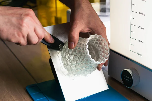 Yanında 3 boyutlu bir reçine tutan adam makineleri yıkayıp iyileştirir.