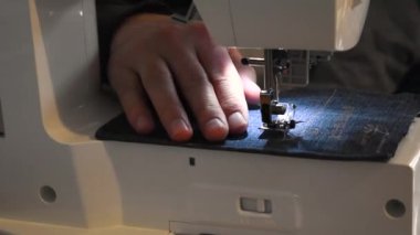 Mavi giysili bir dikiş makinesi kullanan adam ve çocuk, onarım, kişiselleştirme, yaratım, yükseltme