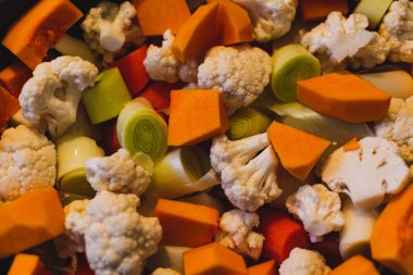 Çiğ sebzeler buhar, karnabahar, tereyağı, pırasa ve havuç için küçük parçalara ayrılırlar.