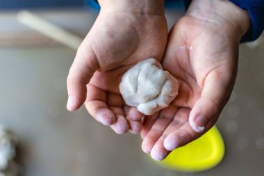 Çocuk tuzlu hamuru modellerken eğleniyor, otantik aktivite, iyi motor beceriler geliştirme