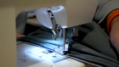 Giysisi olan bir dikiş makinesi kullanan kişi, onarım, kişiselleştirme, yaratım, yükseltme