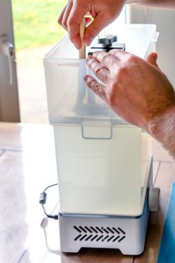 3 boyutlu şeffaf bir reçine nesnesini temizlemek için çamaşır makinesi kullanan bir adam