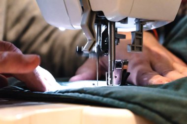 Elbiseli bir dikiş makinesi kullanan adam, onarım, kişiselleştirme, yaratım, yükseltme