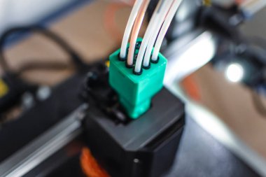 3D yazıcı, tepsiye iplik, mısır nişastası ve su geçirmez iplik içeren bir nesne basıyor.