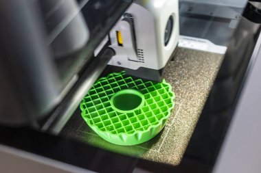 3D yazıcı, tepsiye iplik, mısır nişastası ve su geçirmez iplik içeren bir nesne basıyor.