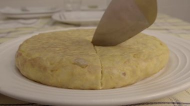 Patates omleti kesip beyaz bir tabakta servis etmek..