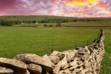 Güneş Kansas Flint Hills 'te bir çiftlikte batıyor.