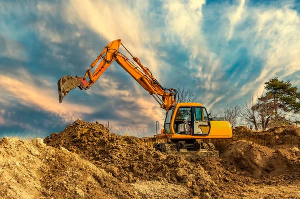 日落时施工现场土方工程中的履带式挖掘机 — 图库照片