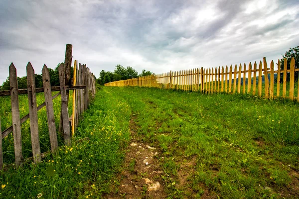木材木板围栏和中间的乡村道路 — 图库照片