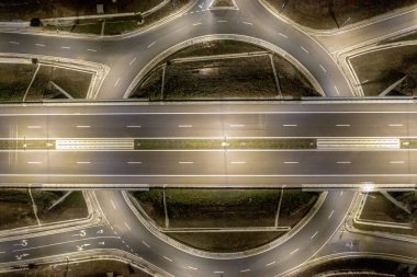 Gece ışığında kentsel otoyol kavşağının hava görüntüsü.