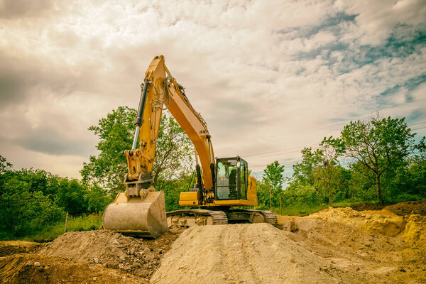 Big excavator working at the construction site.Film camera view
