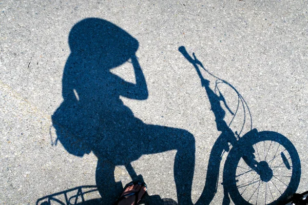 Shadow of cyclist stopping for rest on a bicycle on a road