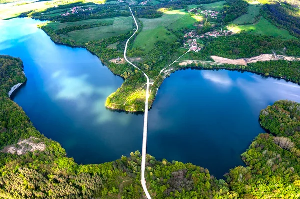 aerial view from a drone to a lake and a road between hills.
