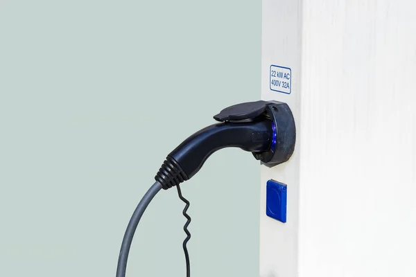 Closeup of charger plug to an electric vehicle from charging station.