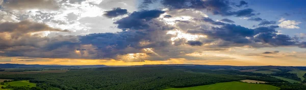 田舎のパノラマ航空ビューと太陽の光線で曇った空 緑の森に覆われた田舎 — ストック写真