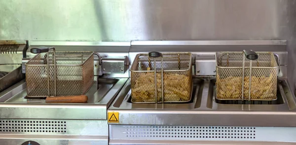 ポテトフライヤーでフライパンの準備ジャガイモ ファーストフードレストランのコンセプト キッチン機器 ストック画像