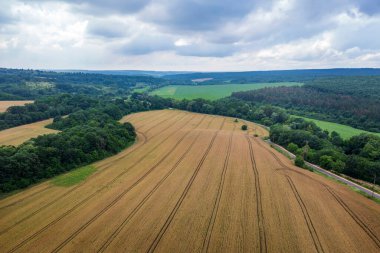 Tarım tarlasında traktör izleri olan bir tarlanın havadan görüntüsü..