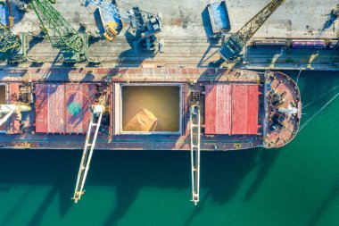 Top view from a drone of a large ship loading grain for export. Water transport  clipart