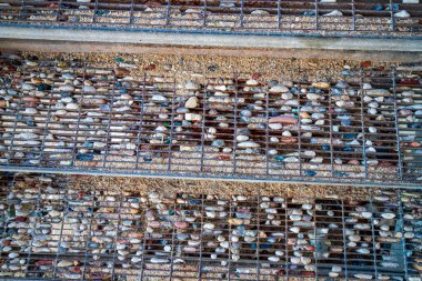 Çakıl taşlı metal parmaklıklar. Kapat.