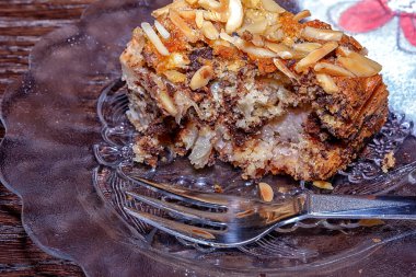 Çikolatalı pastanın bir parçasını yemiş, çatallı bir tabakta fındıklı kek.