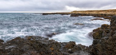 Sersemletici panoramik deniz manzaralı bulutlar denizin üzerinde kayalık kıyılarla