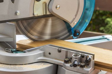 Miter saw in the process of sawing off a wooden part. Close up