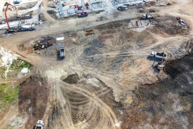 Çalışan birçok ağır makineli büyük inşaat alanının havadan görünüşü