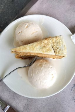 Çatallı bir tabakta lezzetli bir parça kek ve dondurmanın manzarası